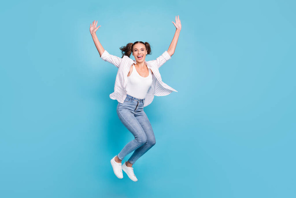 Full length body size view of attractive sporty cheerful girl jumping having fun good day isolated on bright blue color background. - Foto, afbeelding