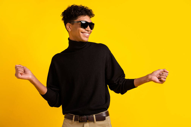Profile photo of optimistic brunet guy dance wear spectacles black sweater isolated on yellow color background. - Fotografie, Obrázek