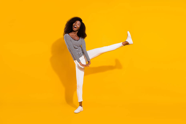 Full length body size photo woman looking empty space dancing keeping leg up isolated bright yellow color background. - Фото, изображение
