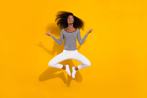 Full length body size photo woman jumping up practicing yoga lotus flower isolated vibrant yellow color background. - Fotó, kép