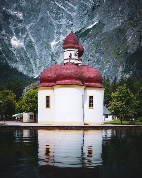 A vertical shot of St. Bartholomew's church near the lake in Konigsee, Germany - Photo, Image