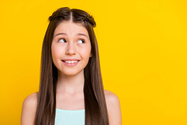 Photo of dreamy minded happy little girl look empty space good mood isolated on yellow color background. - Фото, изображение