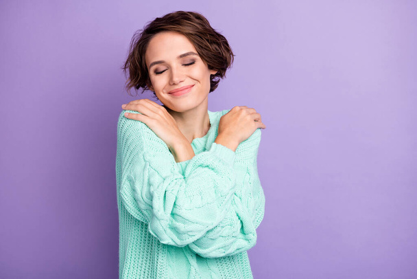 Portrait of attractive cheerful dreamy brown-haired girl hugging herself warm clothes isolated over violet purple color background. - Foto, Imagem