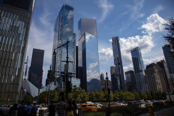 Eine schöne Aufnahme moderner Wolkenkratzer, die den wolkenverhangenen Himmel in New York City widerspiegeln. - Foto, Bild