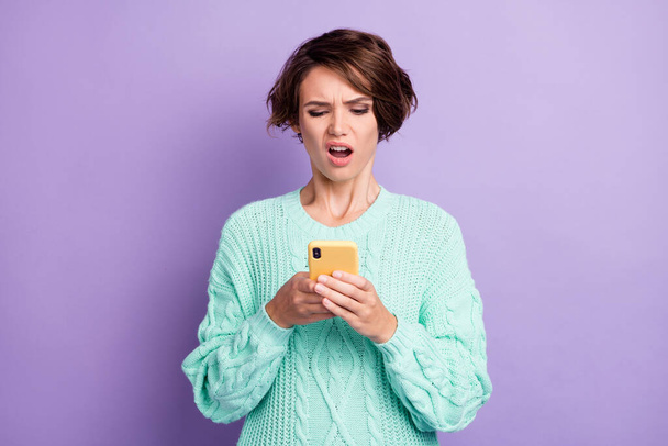 Photo portrait of girl unhappy reading fake news using app on mobile phone browsing internet isolated on pastel violet color background. - Zdjęcie, obraz