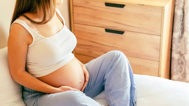 Γιόγκα διαλογισμού εγκυμοσύνης. Νεαρή έγκυος μητέρα διαλογίζεται ενώ κάθεται σε στάση λωτού. Γιόγκα στο σπίτι. Έννοια της εγκυμοσύνης, μητρότητας, προσδοκία για τη γέννηση του μωρού - Φωτογραφία, εικόνα