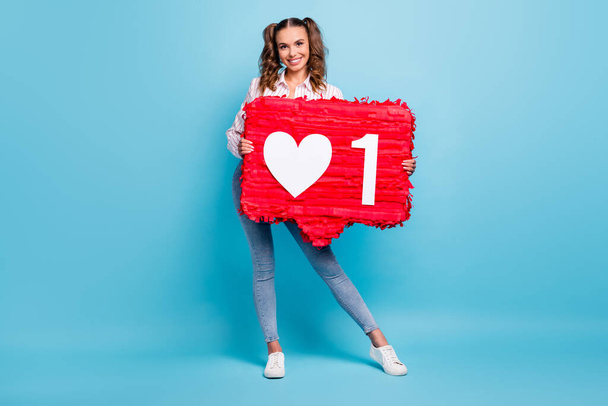 Full length body size view of lovely cheerful girl holding in hands big sign thumbup like approve isolated over bright blue color background. - Фото, изображение