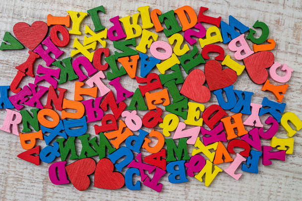 Stapel von bunten kleinen Holzbuchstaben für die Grundschule. Englische Buchstaben in chaotischer Reihenfolge auf Holztisch - Foto, Bild