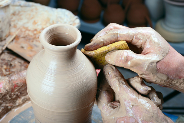 Botella de cerámica en la rueda de un alfarero.Procesamiento por una esponja
 - Foto, imagen