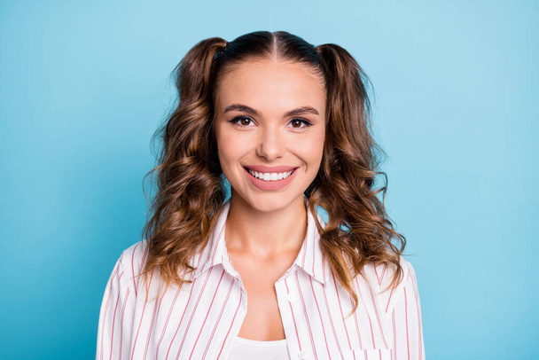 Photo portrait of happy girl with ponytails smiling in striped shirt isolated on bright blue color background. - Fotó, kép