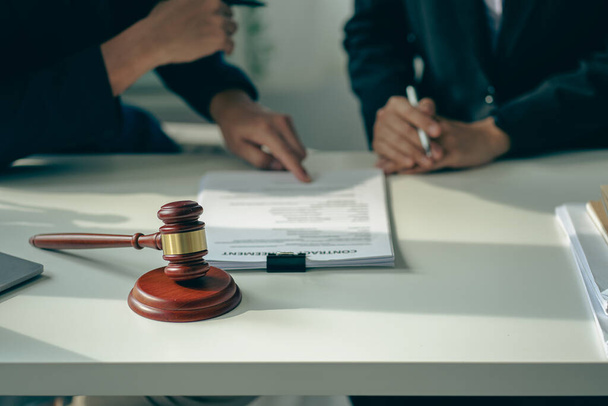 Male attorneys or judges consult teams with clients, business and legal services. The consultant presents the contract signed with the hammer placed in front and concept of justice and lawyer - Zdjęcie, obraz