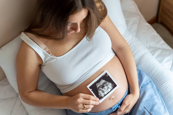 Ultrazvuk těhotné dítě foto. Žena s ultrazvukovou těhotenskou fotkou. Těhotenství, medicína, farmacie, zdravotnictví a lidé koncepce - Fotografie, Obrázek