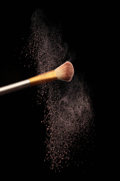 Макияж кисть с косметическим брызги порошка, на черном фоне. Разбрызгивание - Фото, изображение