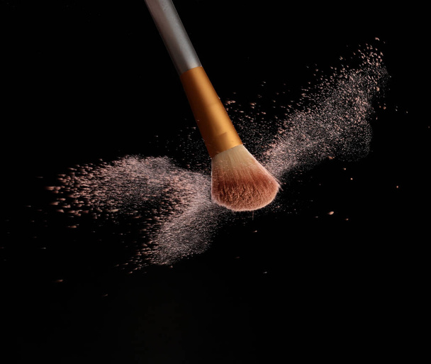 Maquiagem escova com respingo de pó cosmético, sobre fundo preto. Imagem de respingo - Foto, Imagem