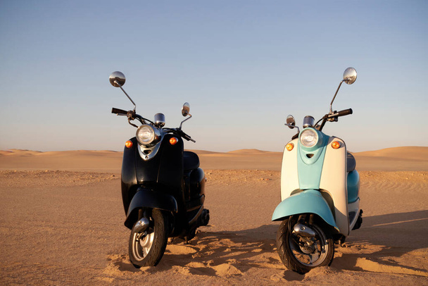 Two Retro scooters at sunset in the golden sand of the Namib Desert - Photo, Image