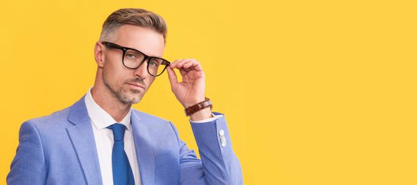 dospělý muž ve formalwear a brýle na žlutém pozadí, manažer. Muž tvář portrét, prapor s kopírovacím prostorem - Fotografie, Obrázek