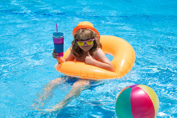 Kinder schwimmen und spielen in einem Pool. Kind spielt im Schwimmbad. Kinderporträt Sommermode. Urlaub in einem tropischen Ferienort. Bademode für Kinder. Sommerpause und Entspannung - Foto, Bild