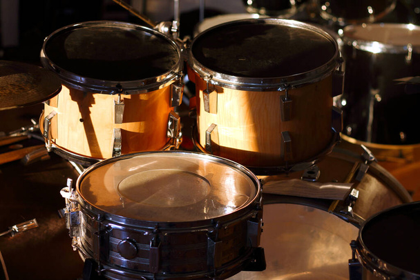 Conjunto de tambores iluminado pelos raios do sol poente em um estúdio de música. Fechar.. - Foto, Imagem