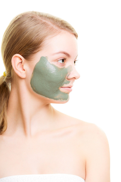 Woman with clay mud mask on face. - Φωτογραφία, εικόνα