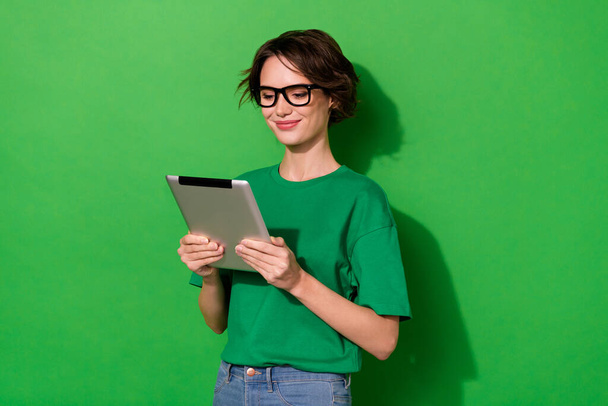 Portrait of positive nice girl hold use tablet write typing message isolated on green color background. - Foto, Bild
