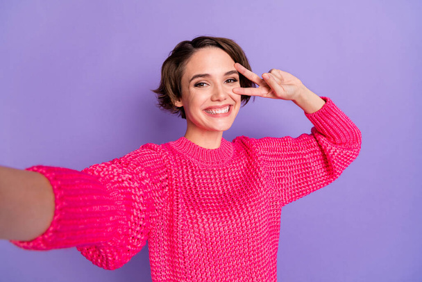 Photo of young attractive girl happy positive smile playful show peace cool v-sign make selfie isolated over violet color background. - Фото, изображение