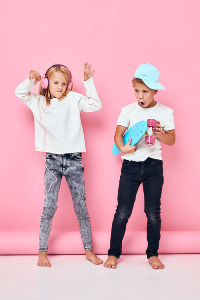 ένα αγόρι σε ένα καπέλο και ένα κορίτσι ενεργή διασκέδαση ανάπαυσης απομονωμένο υπόβαθρο. Υψηλής ποιότητας φωτογραφία - Φωτογραφία, εικόνα