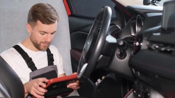 The mechanic maintains the vehicle with the help of diagnostic computer equipment - modern equipment in the car service. The latest computer diagnostics of the car. - Footage, Video