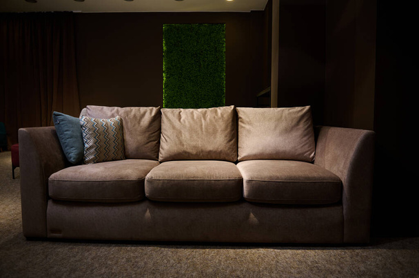 Canapé élégant, moderne, minimaliste et confortable avec des oreillers exposés à la vente dans un studio de design d'intérieur et magasin de meubles - Photo, image