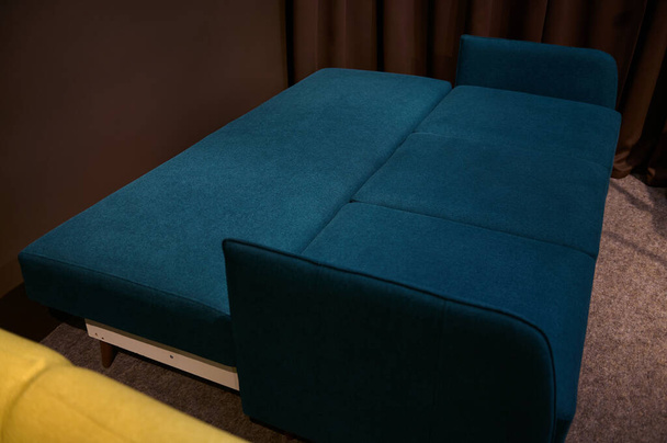 Elegante moderno minimalista cómodo y ortopédico sofá cama azul oscuro y verde en una forma plegable, en exhibición en una tienda de muebles. Inicio concepto de diseño de interiores - Foto, imagen