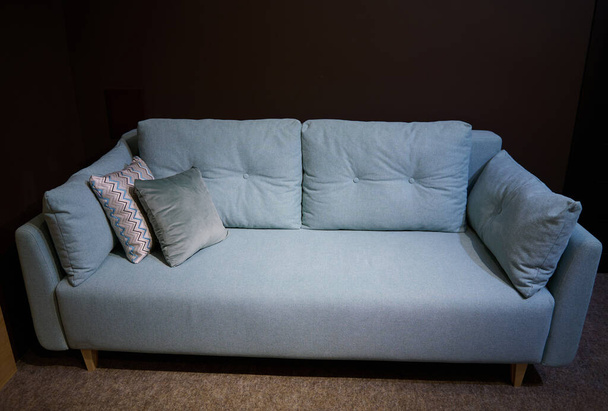 Hermoso cómodo minimalista elegante art nouveau sofá turquesa con cojines estampados en el centro de exposición de la tienda de muebles. Inicio estudio de diseño de interiores - Foto, imagen