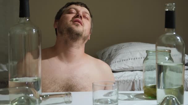 Un uomo con dipendenza da alcol beve alcol da un bicchiere e tossisce. - Filmati, video