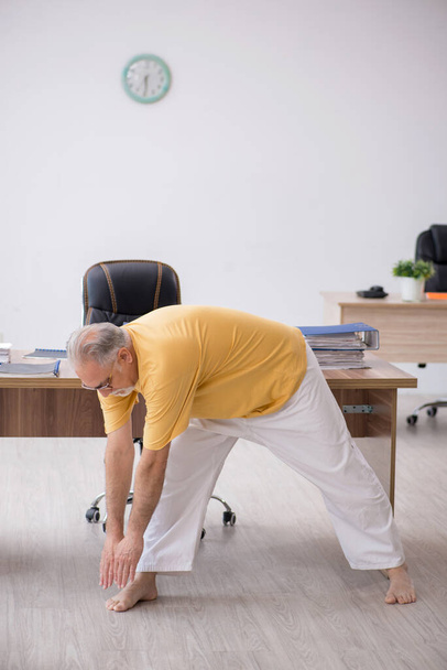 Old boss doing sport exercises during break - Photo, Image