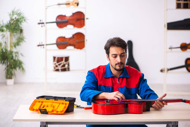 Молодий ремонтант ремонтує музичні інструменти на робочому місці
 - Фото, зображення