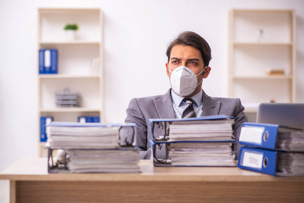Jeune homme d'affaires travaillant sur le lieu de travail pendant la pandémie - Photo, image