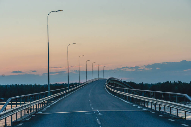 A highway bridge over a river in Sweden - a sunset sky in the background - Foto, Imagen