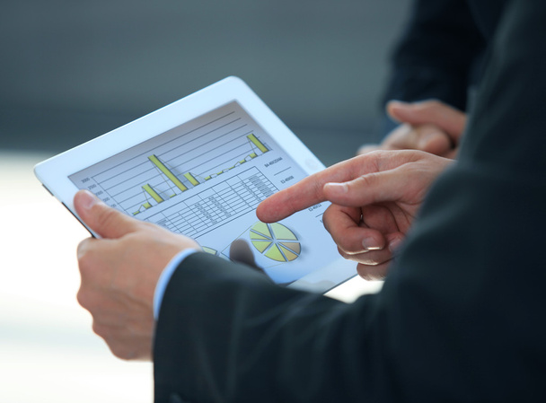 Homme d'affaires analysant les statistiques financières affichées sur l'écran de la tablette
 - Photo, image