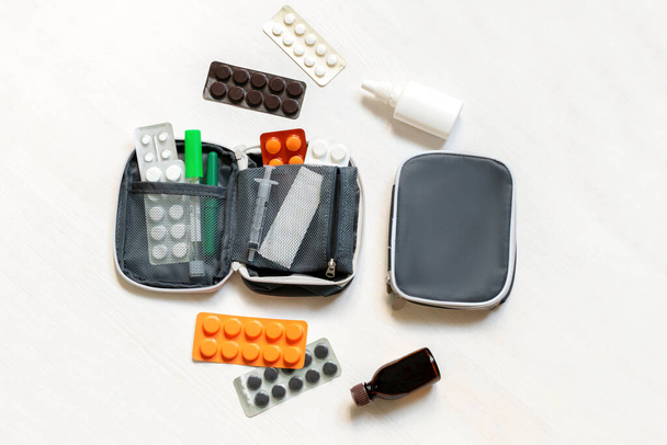 Dagelijkse medicijnkist, verpakking met pillen, tabletten, vitaminen, reisverbanddoos. pil doos dispenser medicijnen, voedingssupplementen. medische behandeling voor de dosering van het ziektevirus in de geneeskunde. - Foto, afbeelding