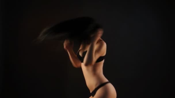 Sexy brunette woman in black lingerie dancing in the dark - Materiał filmowy, wideo