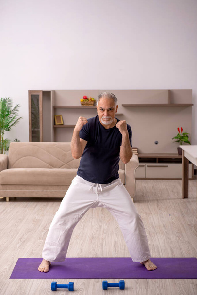 Γέρος που κάνει αθλητικές ασκήσεις σε εσωτερικούς χώρους - Φωτογραφία, εικόνα