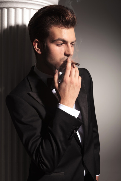 Bonito homem de negócios fumando um cigarro
 - Foto, Imagem
