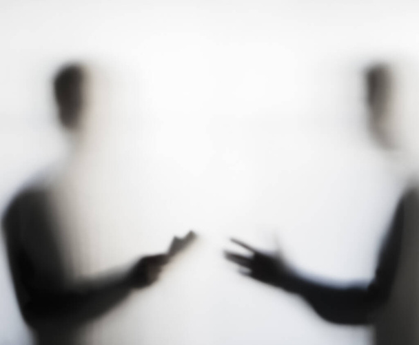 Dos hombres negociando dudosamente detrás de un concepto de cortina - Foto, imagen