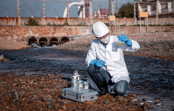 scientist wearing protective  uniform and glove under working water analysis and water quality by get waste water to check case in laboratory is environment pollution problem concept - Φωτογραφία, εικόνα