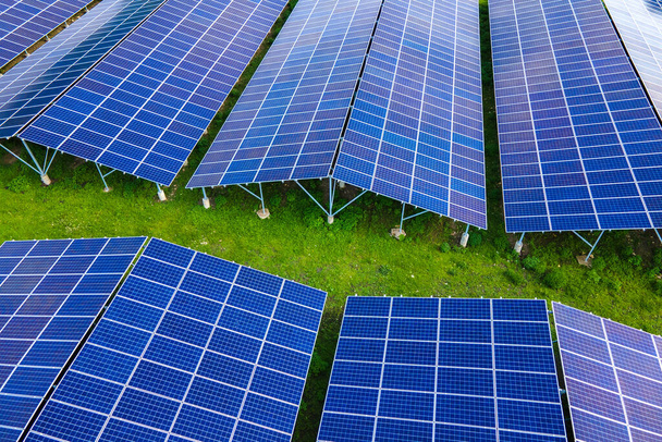 Temiz ekolojik elektrik enerjisi üretmek için sıra sıra güneş fotovoltaik panelleri olan sürdürülebilir büyük elektrik santralinin havadan görünüşü. Sıfır emisyon kavramı ile yenilenebilir elektrik. - Fotoğraf, Görsel