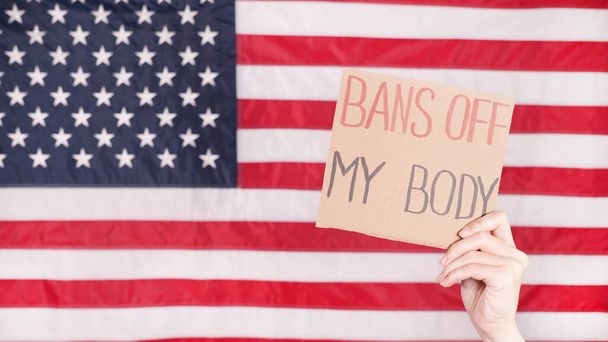 Vrouw met een bord My Body, My Choice Amerikaanse vlag op de achtergrond. Protest tegen de anti abortuswet. Vrouwenstaking. Vrijheid van vrouwen - Foto, afbeelding