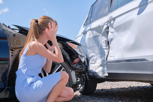 Surullinen naiskuljettaja istui kadulla järkyttyneenä auto-onnettomuuden jälkeen. Liikenneturvallisuuden ja liikennevakuutuksen käsite. - Valokuva, kuva