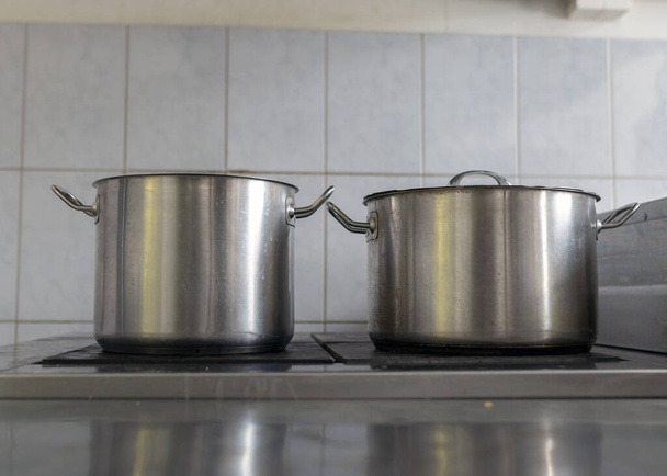 olla de metal en la tapa de la estufa, cocina de la escuela, comer concepto de cocina - Foto, Imagen