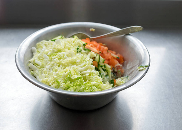 Metallschale mit frischem Salat aus Tomaten, Kohl und Gurken, Essen Kochkonzept - Foto, Bild