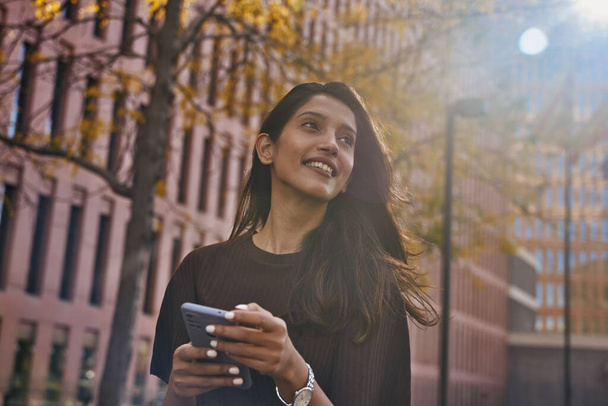 Nuori kaunis cheergul nainen seisoo kadulla matkapuhelimella - Valokuva, kuva