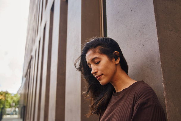 Portrait of serene businesswoman with closed eyes standing against wall - Photo, image