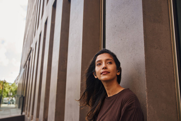 Portrait of beautiful businesswoman standing against wall and looking away - Fotoğraf, Görsel